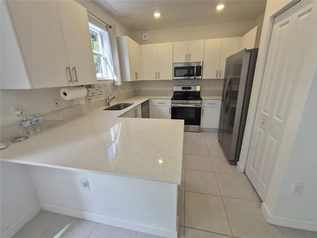 a kitchen with stainless steel appliances a refrigerator sink and microwave