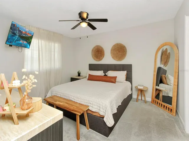 a bedroom with a bed and a mirror on the dresser