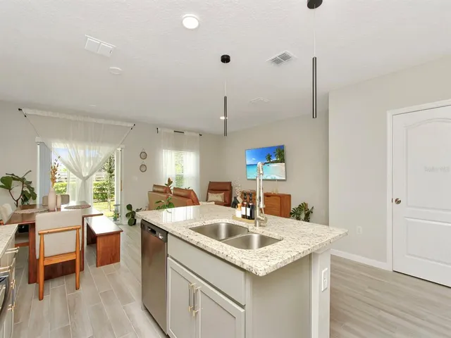 a kitchen with a sink a counter space and wooden floor