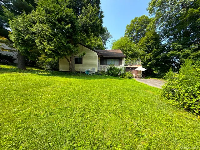 a front view of house with yard and green space