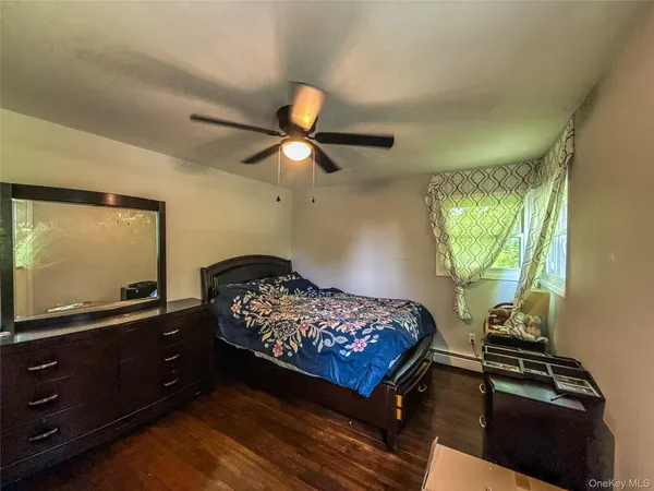 a bedroom with a bed and a flat tv screen on dresser