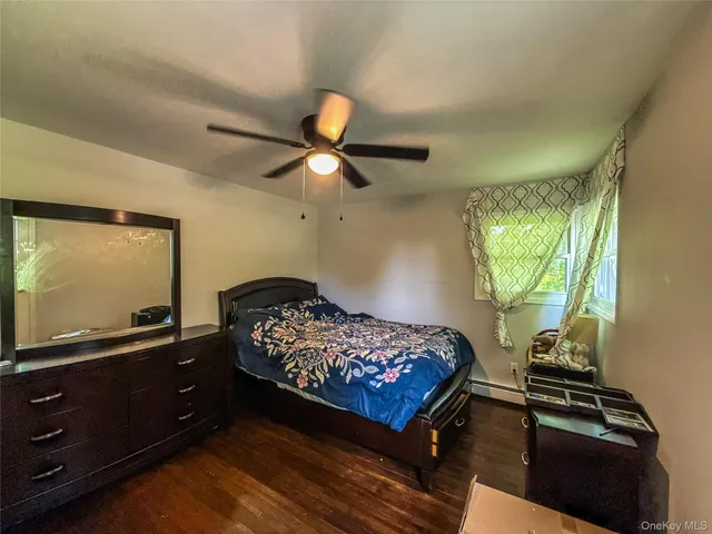 a bedroom with a bed and a flat tv screen on dresser