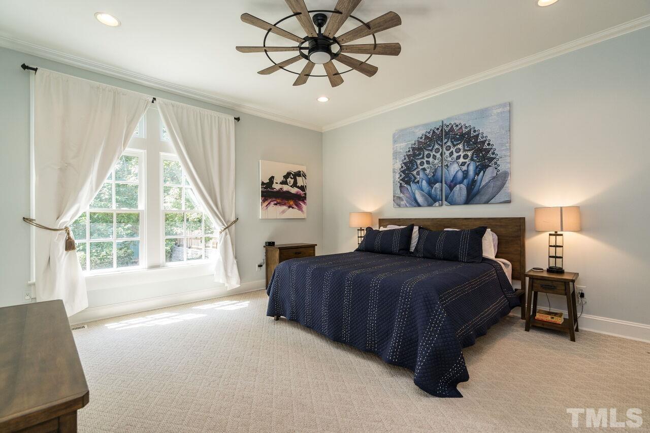 1621 Lorraine Road Raleigh, NC 27607 - Photo 17 of 28 a bedroom with a large bed and a chandelier fan