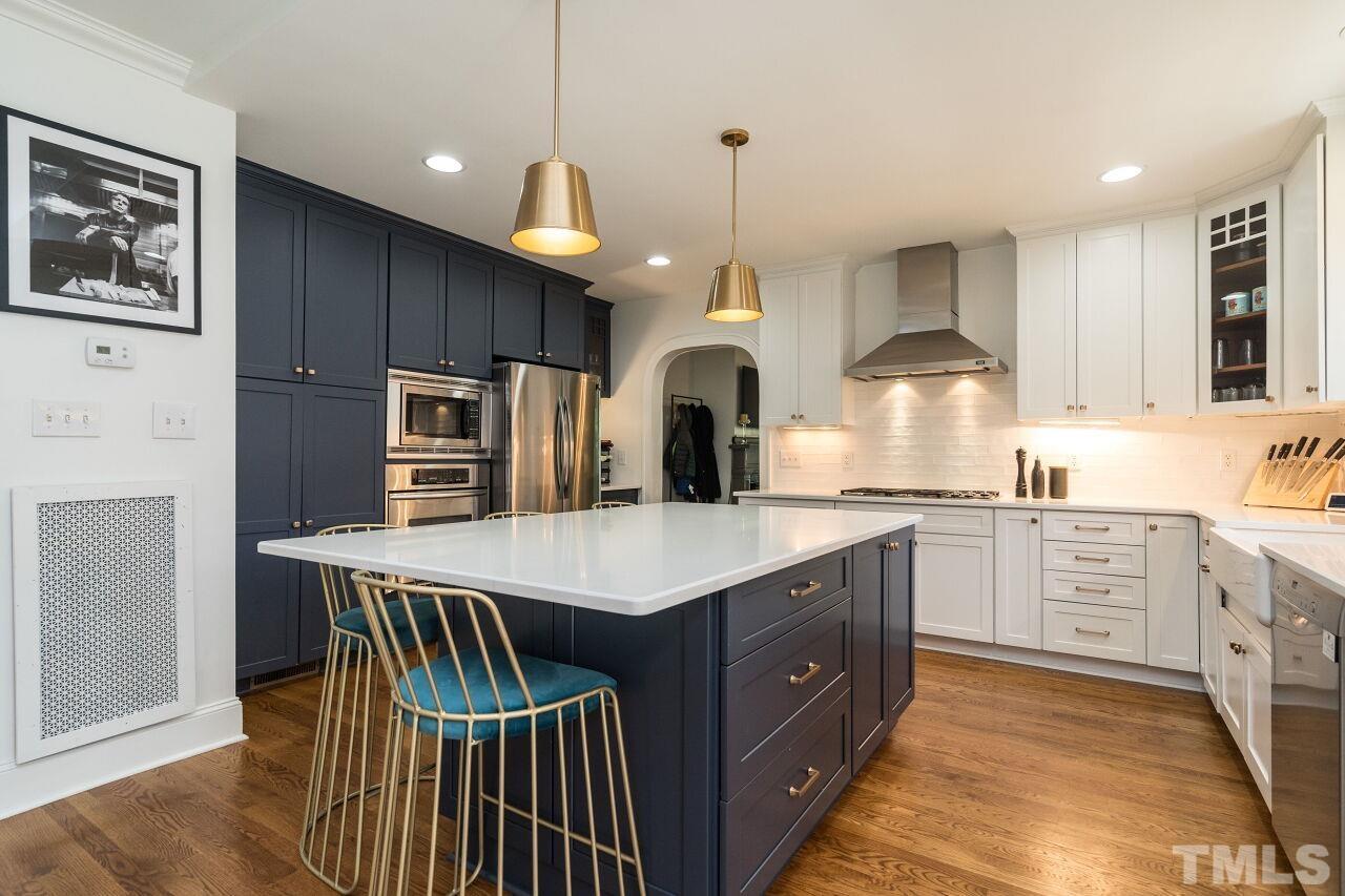 1621 Lorraine Road Raleigh, NC 27607 - Photo 5 of 28 a kitchen with kitchen island granite countertop a stove a sink a center island and cabinets