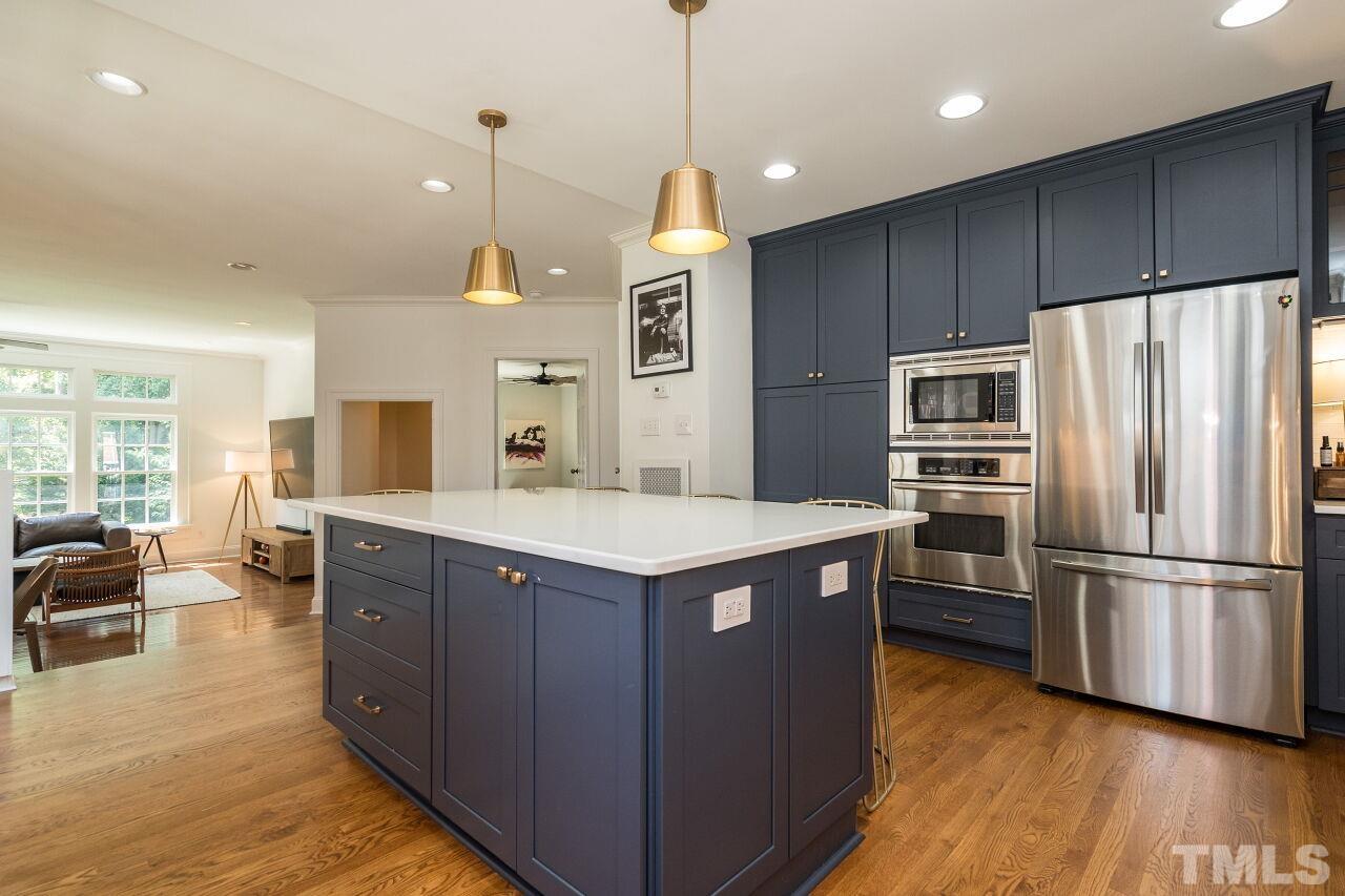 1621 Lorraine Road Raleigh, NC 27607 - Photo 7 of 28 a kitchen with stainless steel appliances granite countertop a refrigerator a stove and a wooden floors