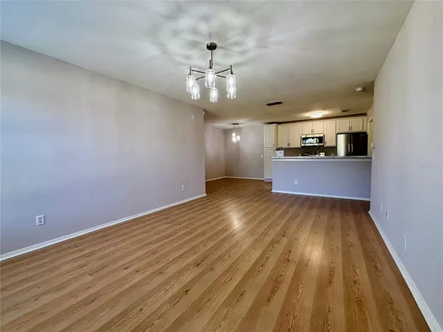 wooden floor in an empty room with a kitchen