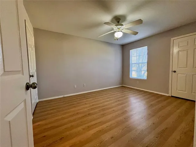 a view of a livingroom with a ceiling fan and wooden floor