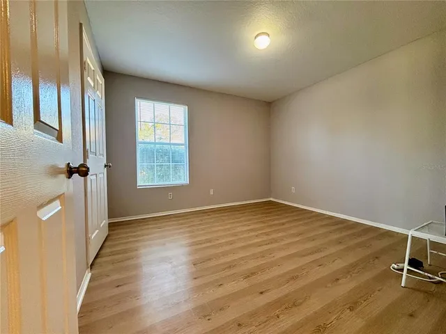 a view of a room with wooden floor and a window