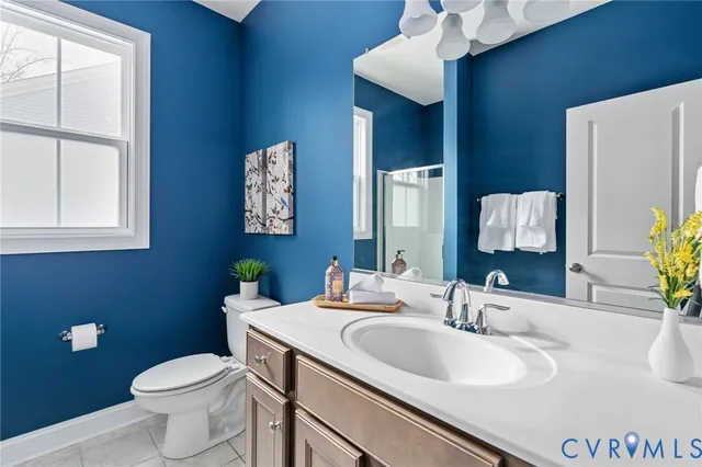 a bathroom with a granite countertop toilet sink and mirror