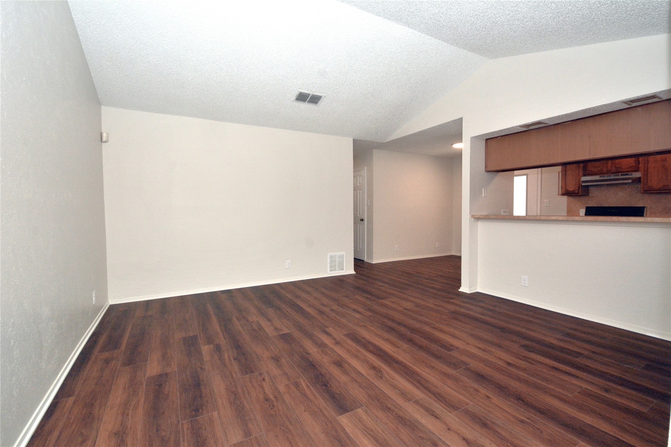 11314 Walnut Ridge Drive, Unit B Austin, TX 78753 - Photo 2 of 19 Rich wood flooring connects an open concept living area to a practical kitchen space.