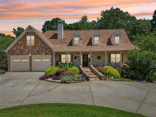 a front view of a house with a yard and potted plants