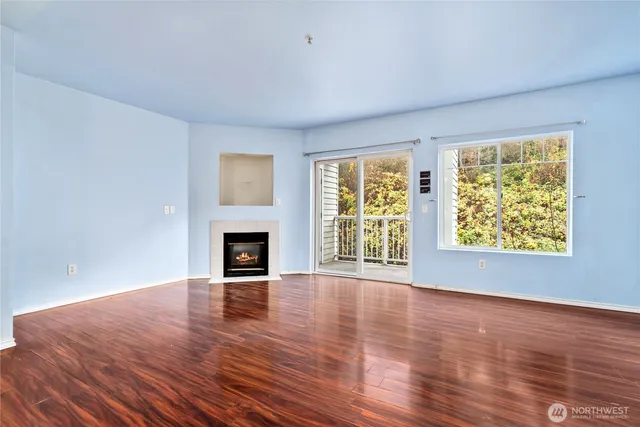 a view of an empty room with window and fire place