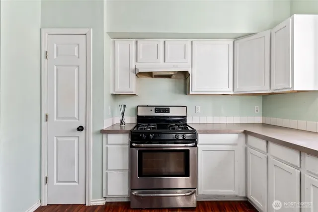 a kitchen with white cabinets and appliances