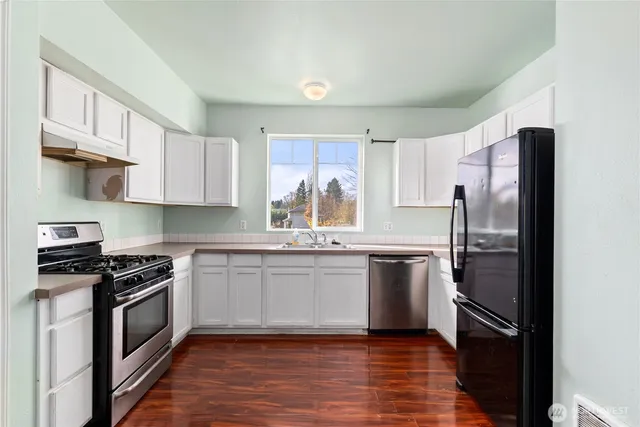 a kitchen with a refrigerator stove top oven and sink