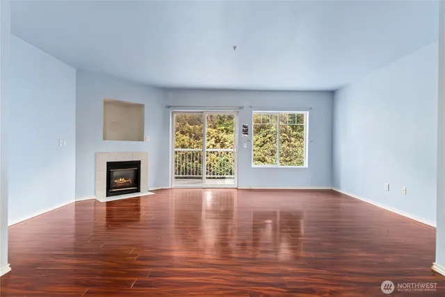 wooden floor fireplace and windows in an empty room