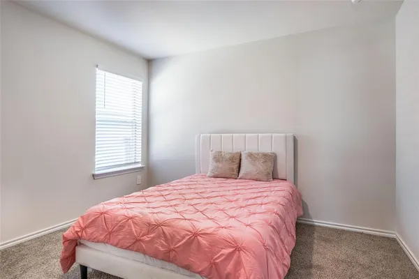 a bed sitting in a bedroom next to a window