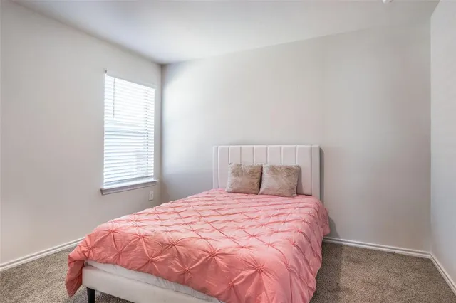 a bed sitting in a bedroom next to a window