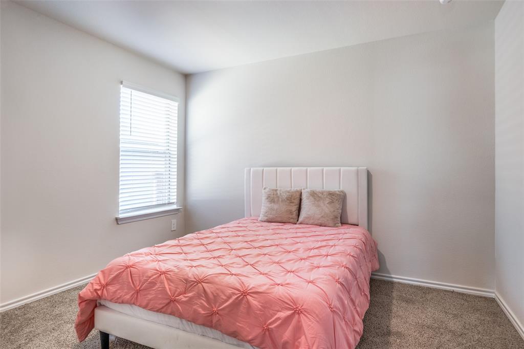803 Sunlight Loop Princeton, TX 75407 - Photo 12 of 16 a bed sitting in a bedroom next to a window