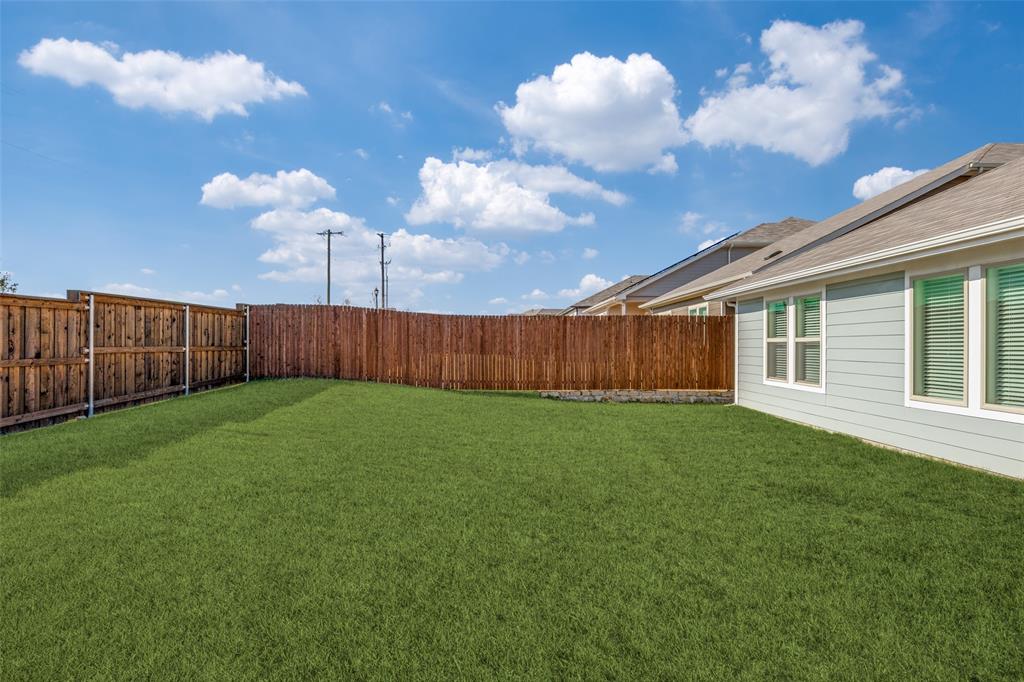 803 Sunlight Loop Princeton, TX 75407 - Photo 16 of 16 a view of a backyard with table and chairs and wooden fence