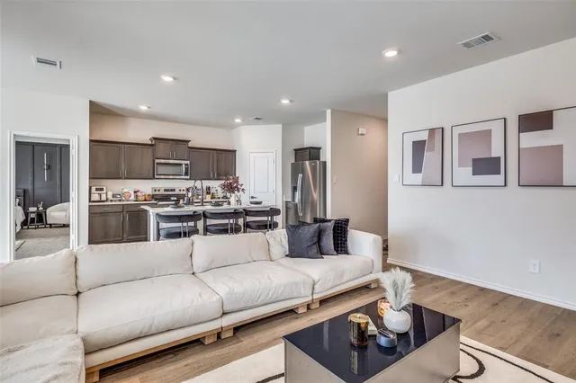 a living room with furniture and kitchen view