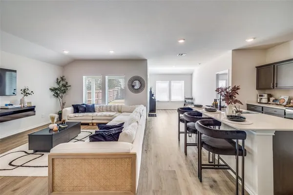 a living room with furniture a flat screen tv and a table
