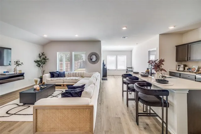 a living room with furniture a flat screen tv and a table