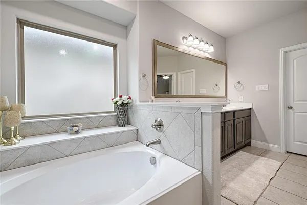 a spacious bathroom with a bathtub sink and mirror