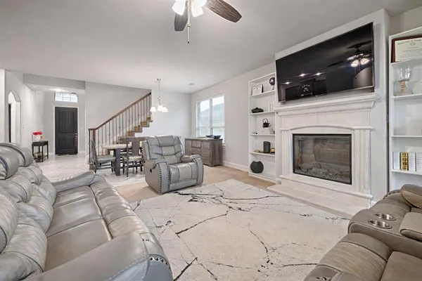 a living room with furniture a flat screen tv and kitchen view