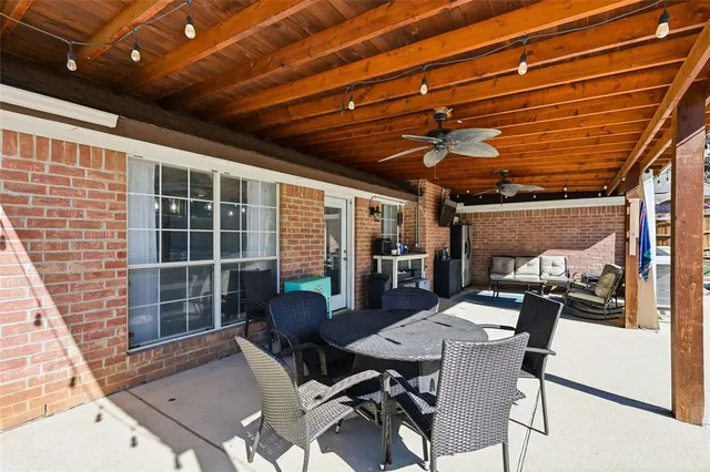 a view of a table and chairs in patio with wooden fence