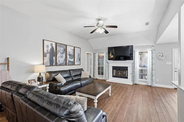 a living room with furniture a fireplace and a flat screen tv