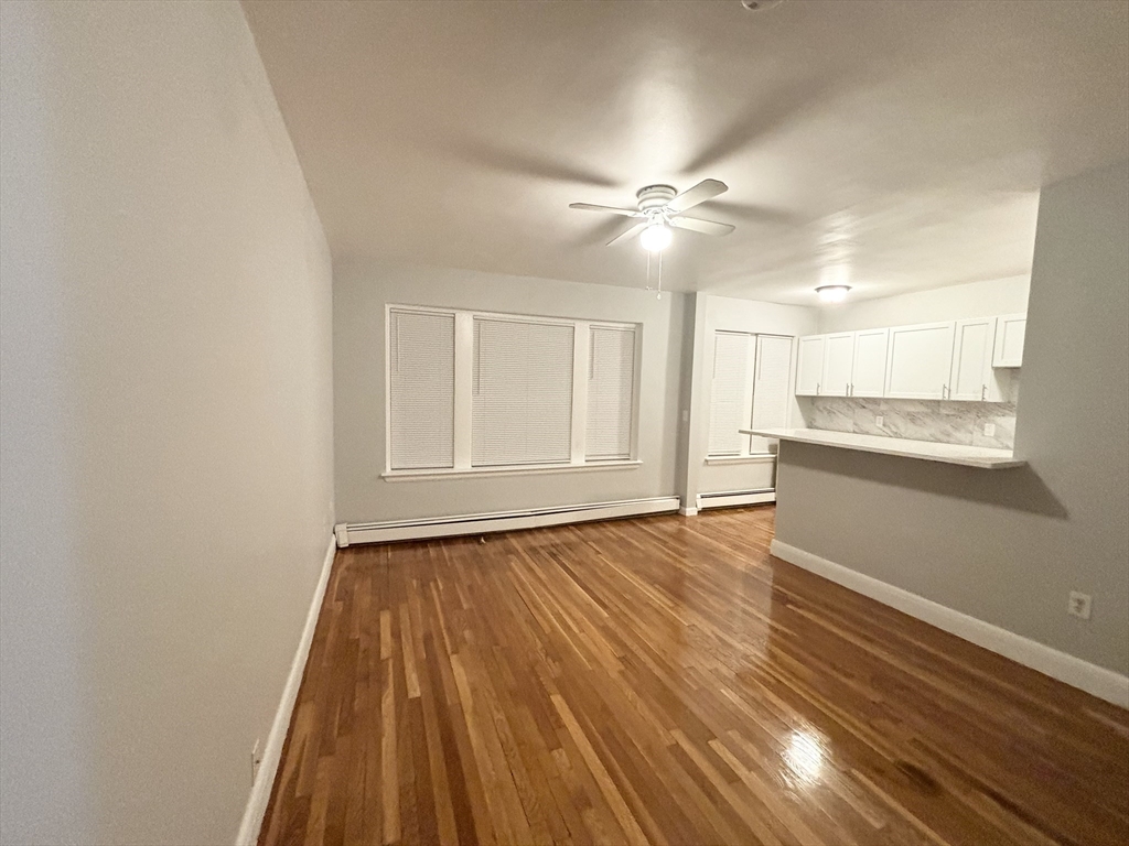15 Ives Street, Unit 6 Beverly, MA 01915 - Photo 3 of 11 a view of an empty room with window and wooden floor