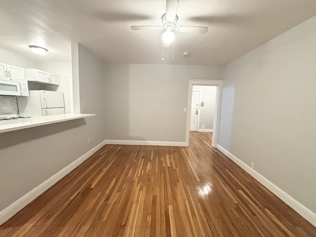 15 Ives Street, Unit 6 Beverly, MA 01915 - Photo 4 of 11 wooden floor in an empty room with a window