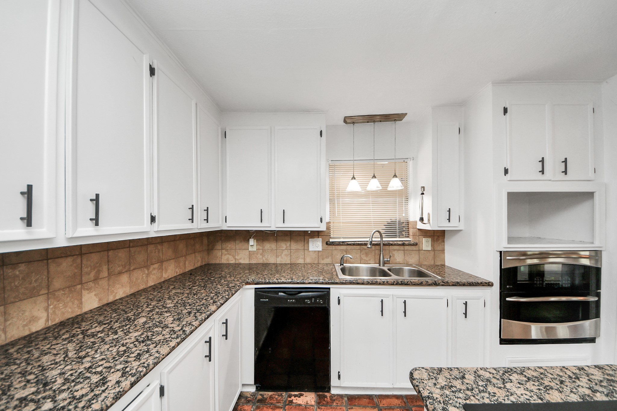 6706 Trebeck Lane Spring, TX 77379 - Photo 12 of 46 a kitchen with granite countertop white cabinets and stainless steel appliances