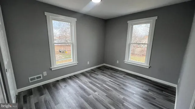 a view of an empty room with wooden floor