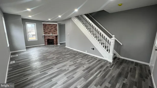 a view of a livingroom with wooden floor and staircase