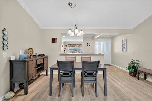 a dining room with furniture a chandelier and wooden floor