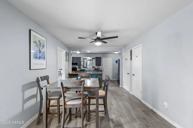 a kitchen with kitchen island granite countertop wooden floors and a view of living room