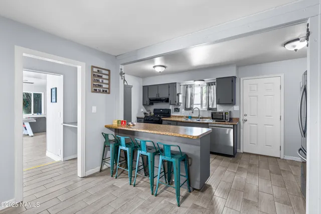 a large kitchen with stainless steel appliances granite countertop a lot of counter space and wooden floors
