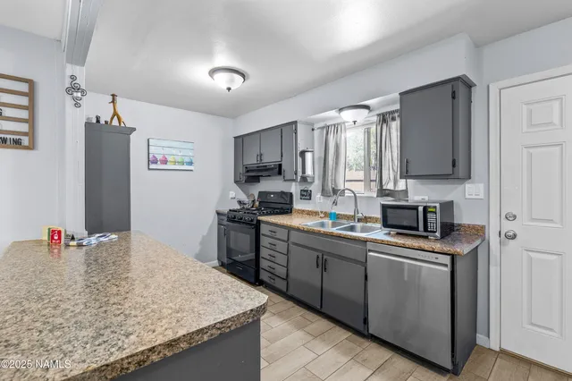 a kitchen with a sink refrigerator and window