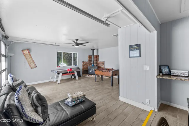 a living room with furniture a flat screen tv and a floor to ceiling window