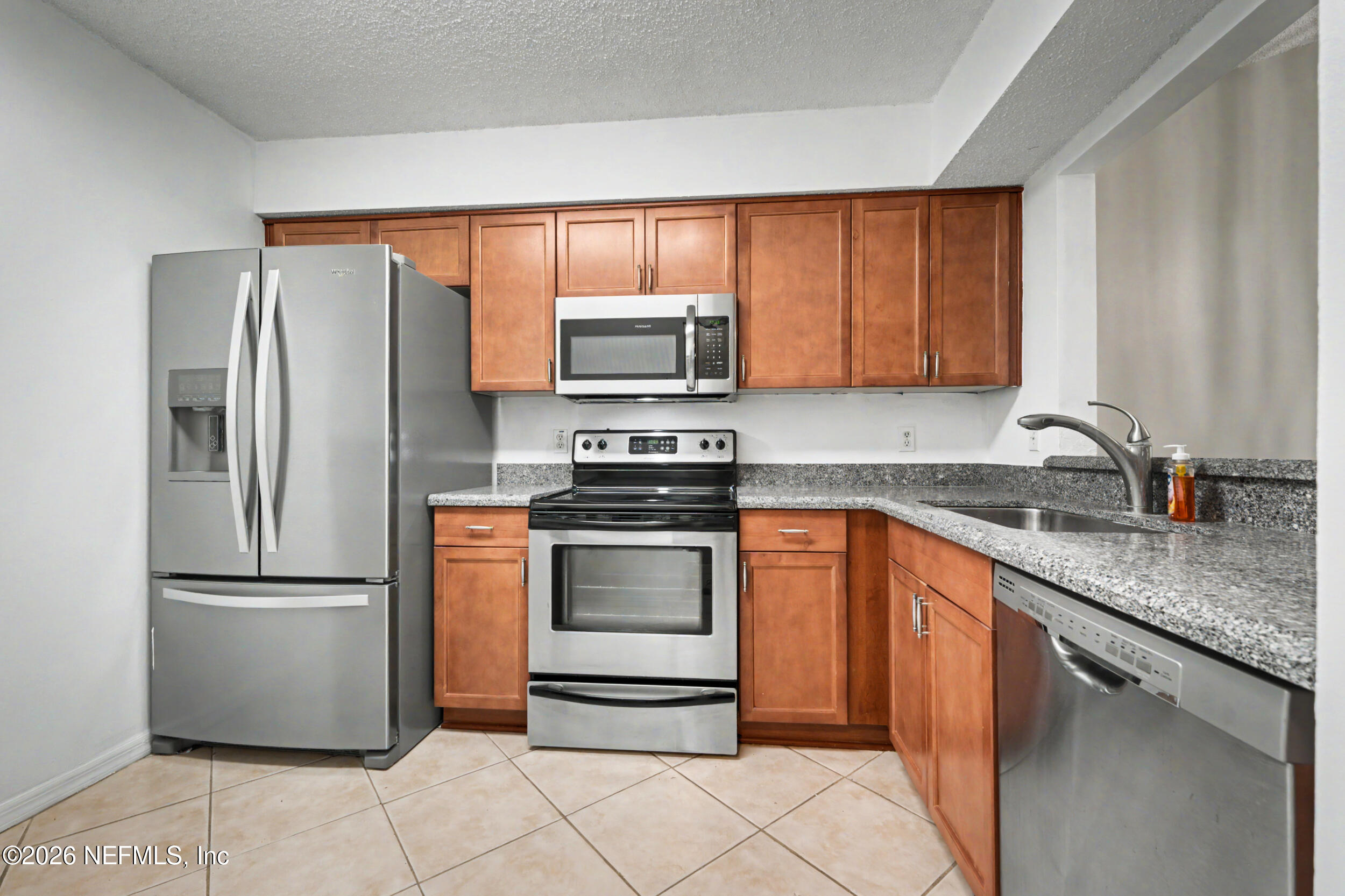 2811 Sea Hawk Drive Ponte Vedra Beach, FL 32082 - Photo 4 of 24 a kitchen with stainless steel appliances granite countertop a refrigerator stove a sink and a microwave