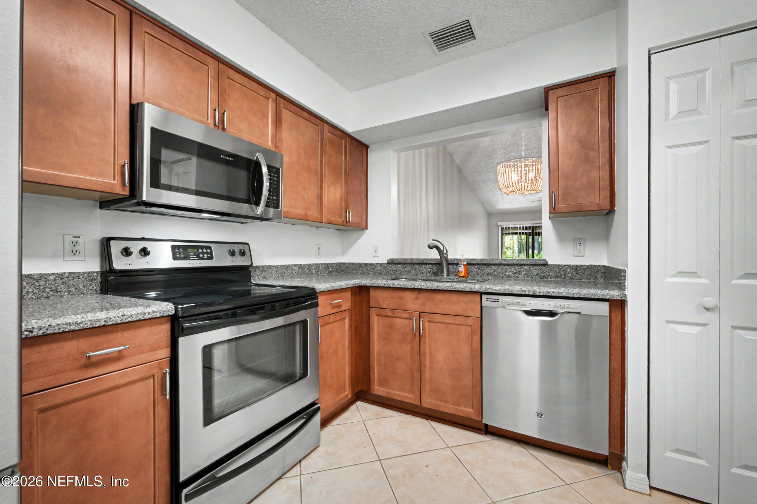 2811 Sea Hawk Drive Ponte Vedra Beach, FL 32082 - Photo 5 of 24 a kitchen with stainless steel appliances granite countertop a stove microwave and sink