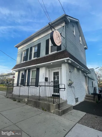 a view of a house with a small yard and wooden fence