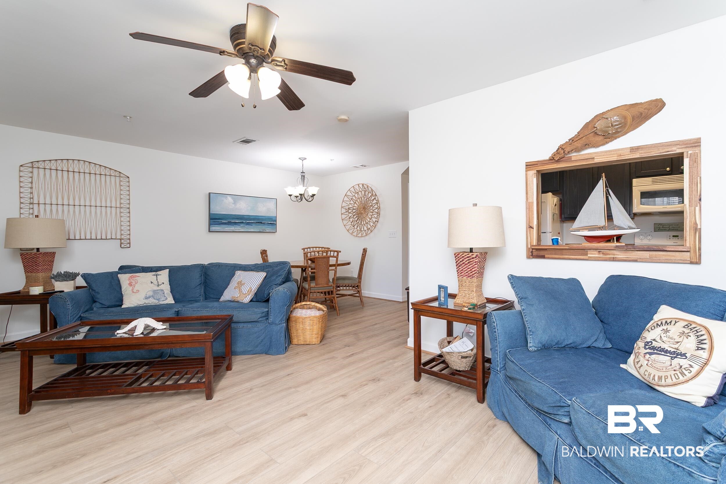 1517 Regency Road, Unit 33 Gulf Shores, AL 36542 - Photo 10 of 29 Living room featuring visible vents, ceiling fan with notable chandelier, baseboards, and wood finished floors
