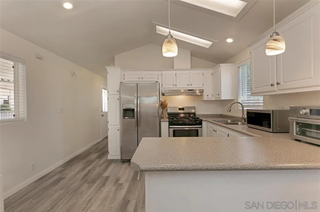 10250 Prospect Avenue, Unit 44 Santee, CA 92071 - Photo 6 of 17 a kitchen with stainless steel appliances a refrigerator a stove a sink and white cabinets