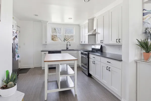 a kitchen with stainless steel appliances a stove a table and chairs