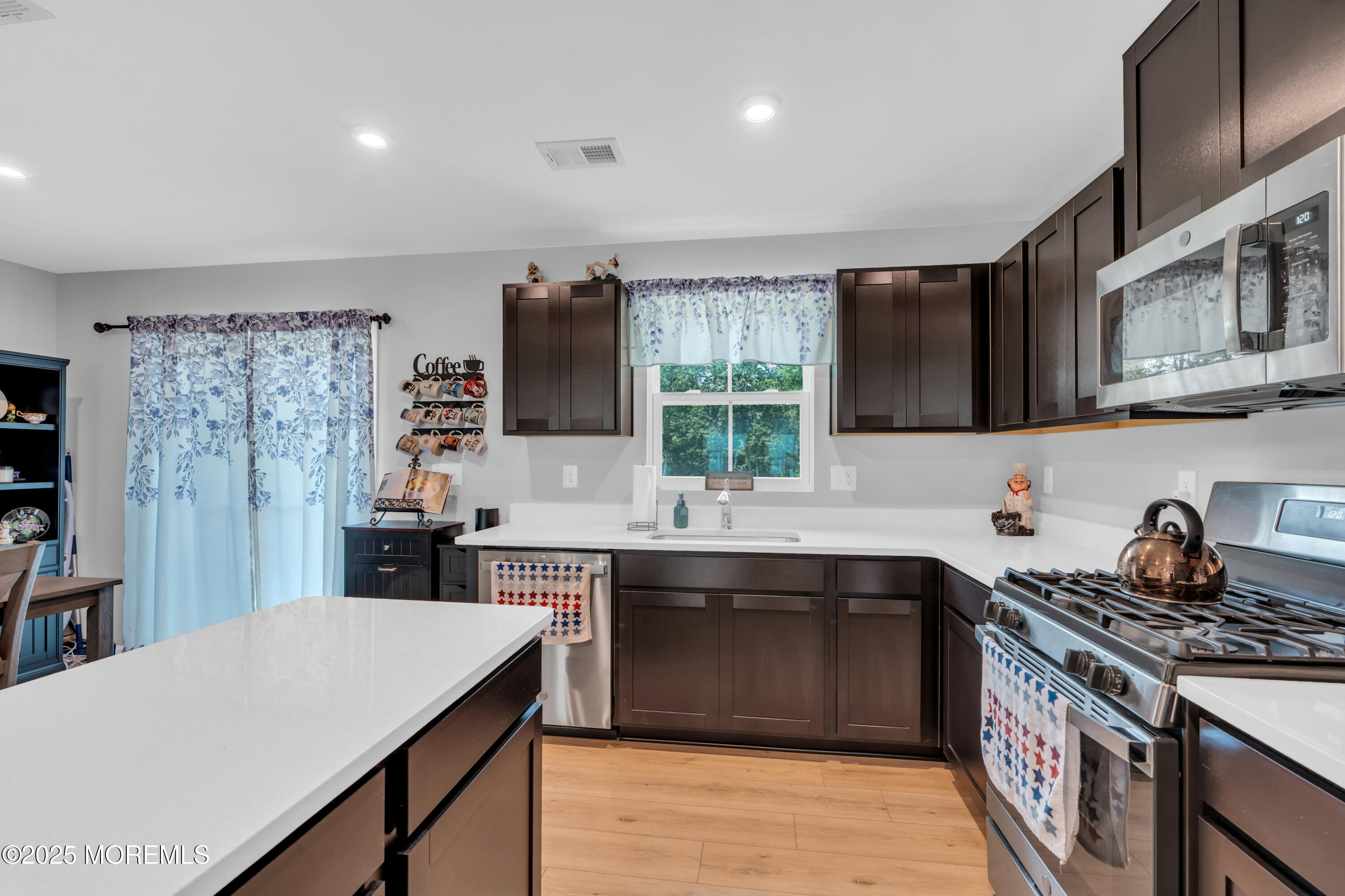 703 Cypress Street Forked River, NJ 08731 - Photo 15 of 50 a kitchen with stainless steel appliances a sink stove top oven and cabinets