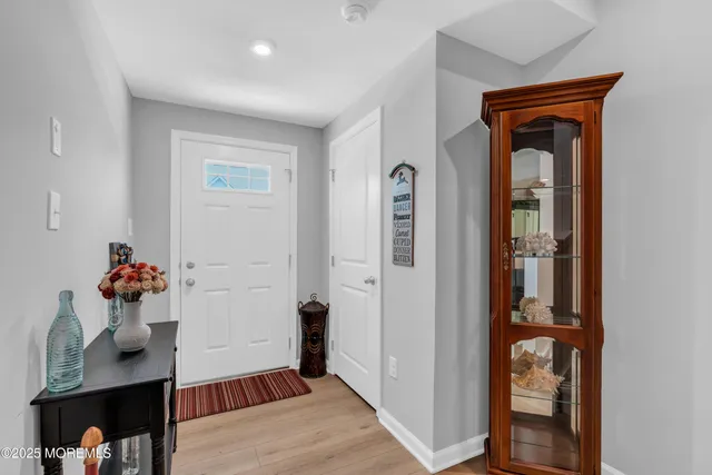 a hallway view with staircase and a living room
