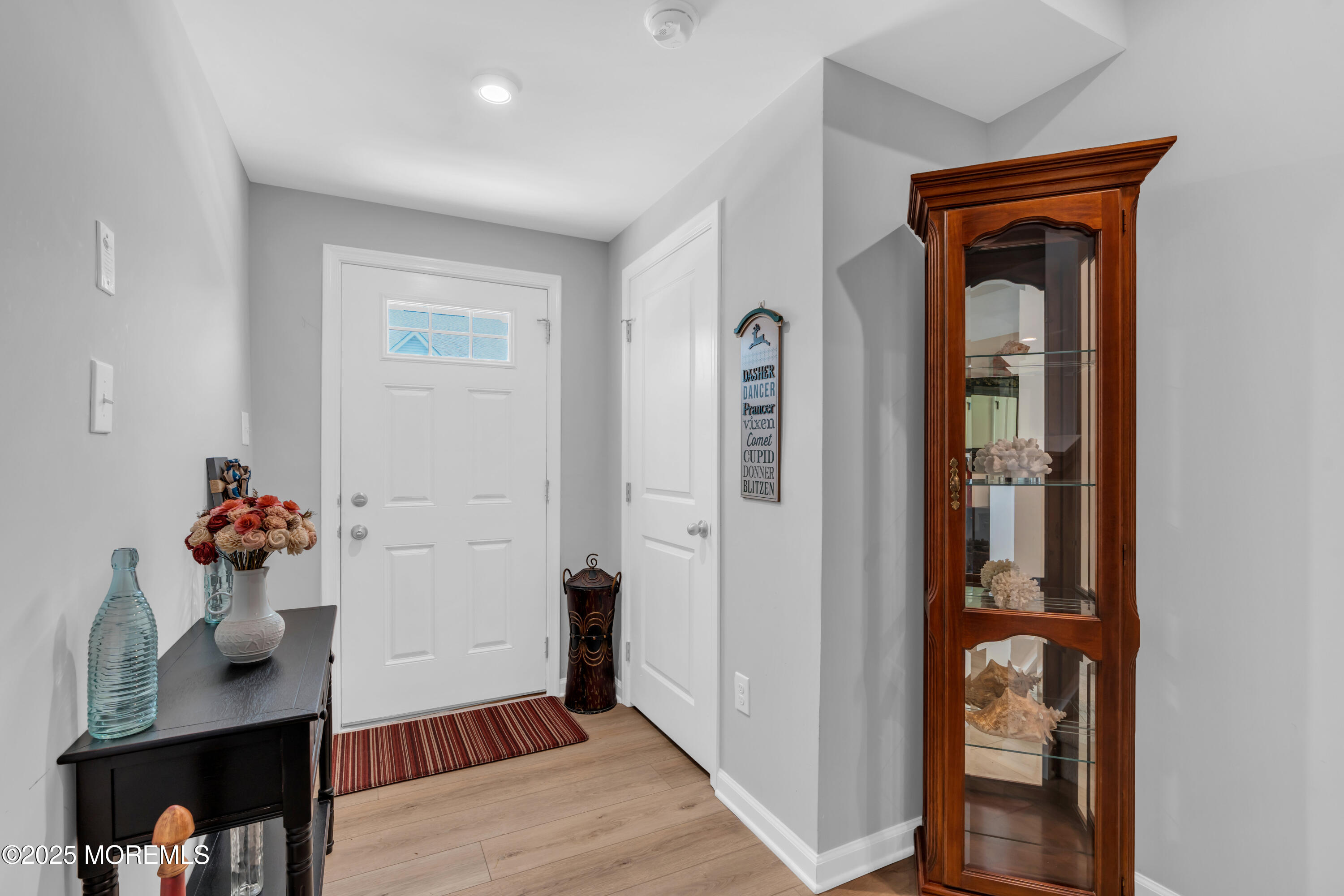 703 Cypress Street Forked River, NJ 08731 - Photo 9 of 50 a hallway with a wooden floor and a table in a room