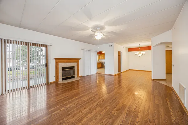 a view of empty room with wooden floor and fireplace